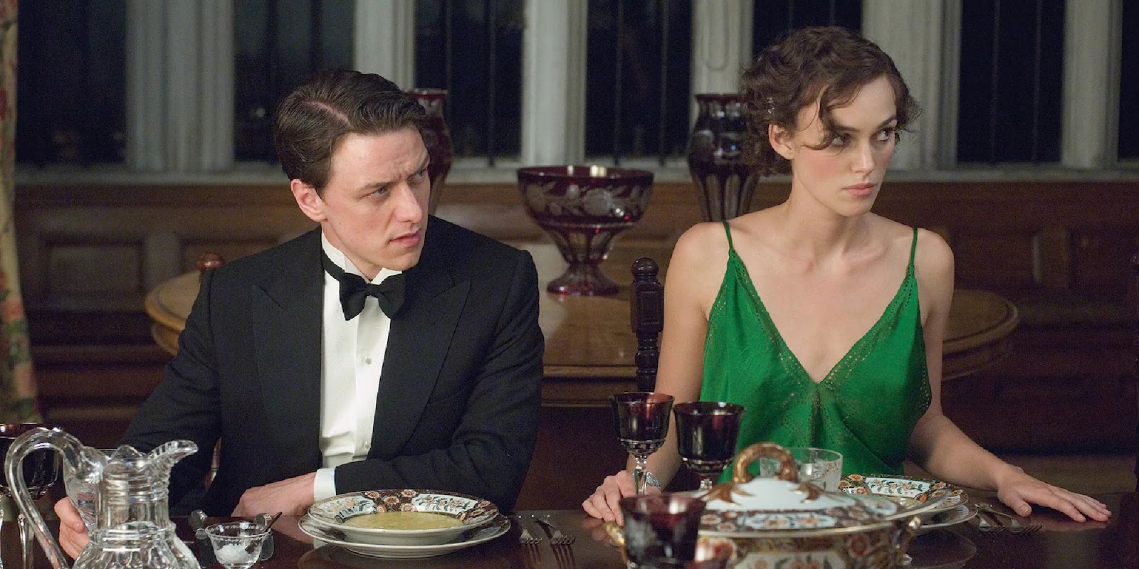 Robbie and Cecilia sitting at the table in a fancy dinner party in 'Atonement'