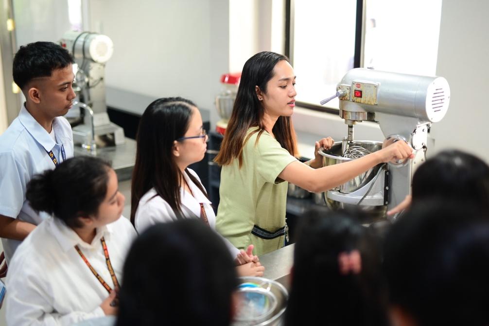 A group of women in a factory

Description automatically generated