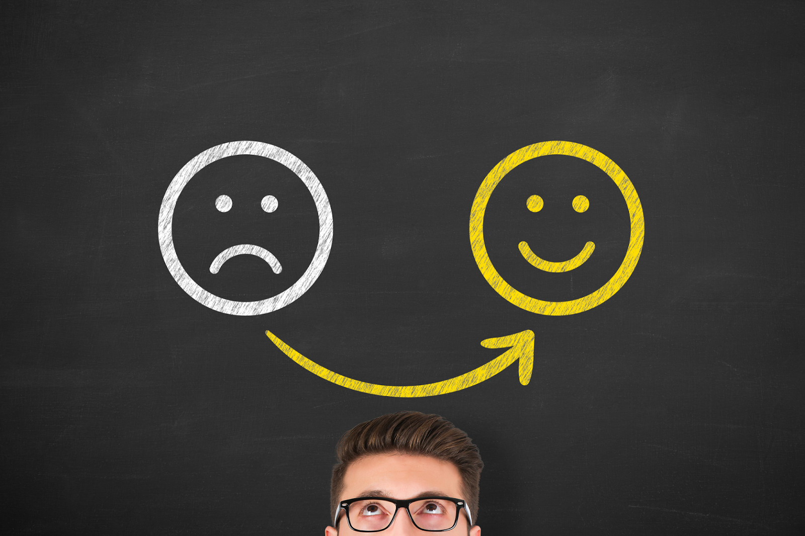 Expert speaker addresses negative feedback in front of blackboard with smiley faces