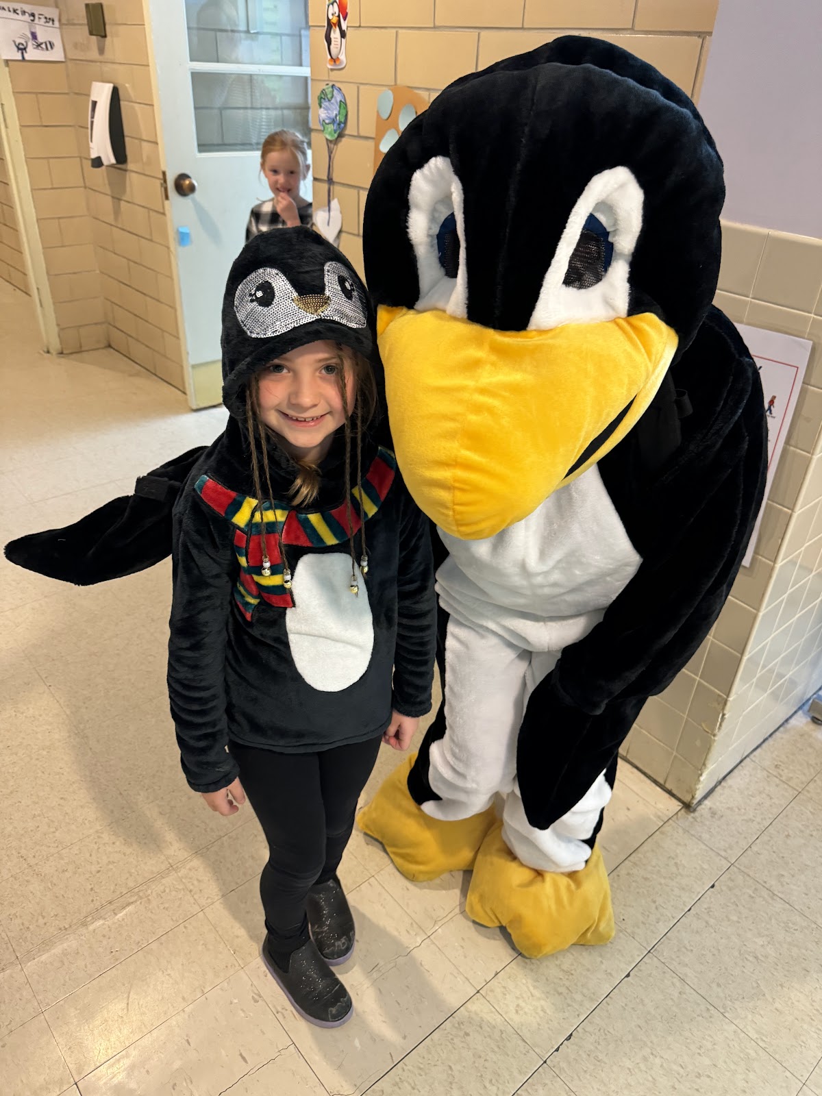 image of a student posing with Jiji the penguin