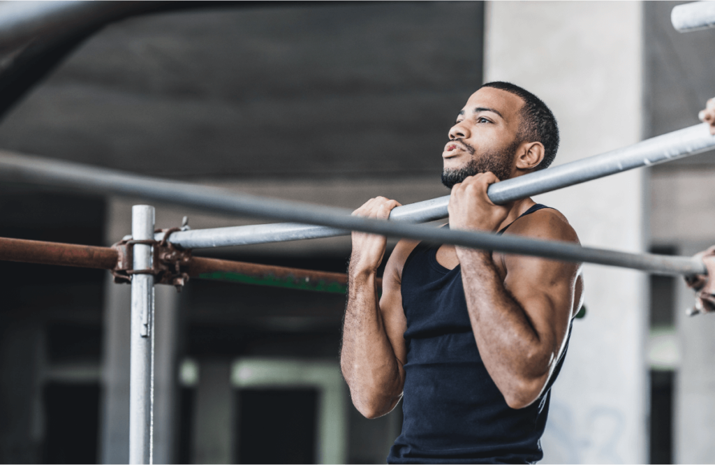 A man performs chin-ups on a pull-up bar