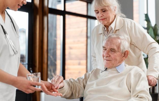 Doctor giving pills to her patient