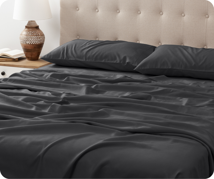 Our charcoal grey Eucalyptus Luxe Sheet Set in Black Pearl shown on a bed.