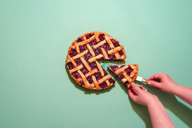 A person's hands holding a piece of pie Description automatically generated