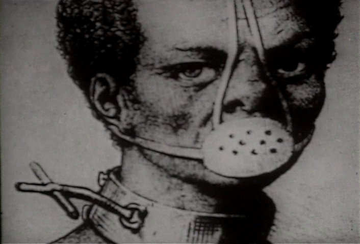 Film still: image of a prson with dark hair with a mask over their mouth and a collar around their neck