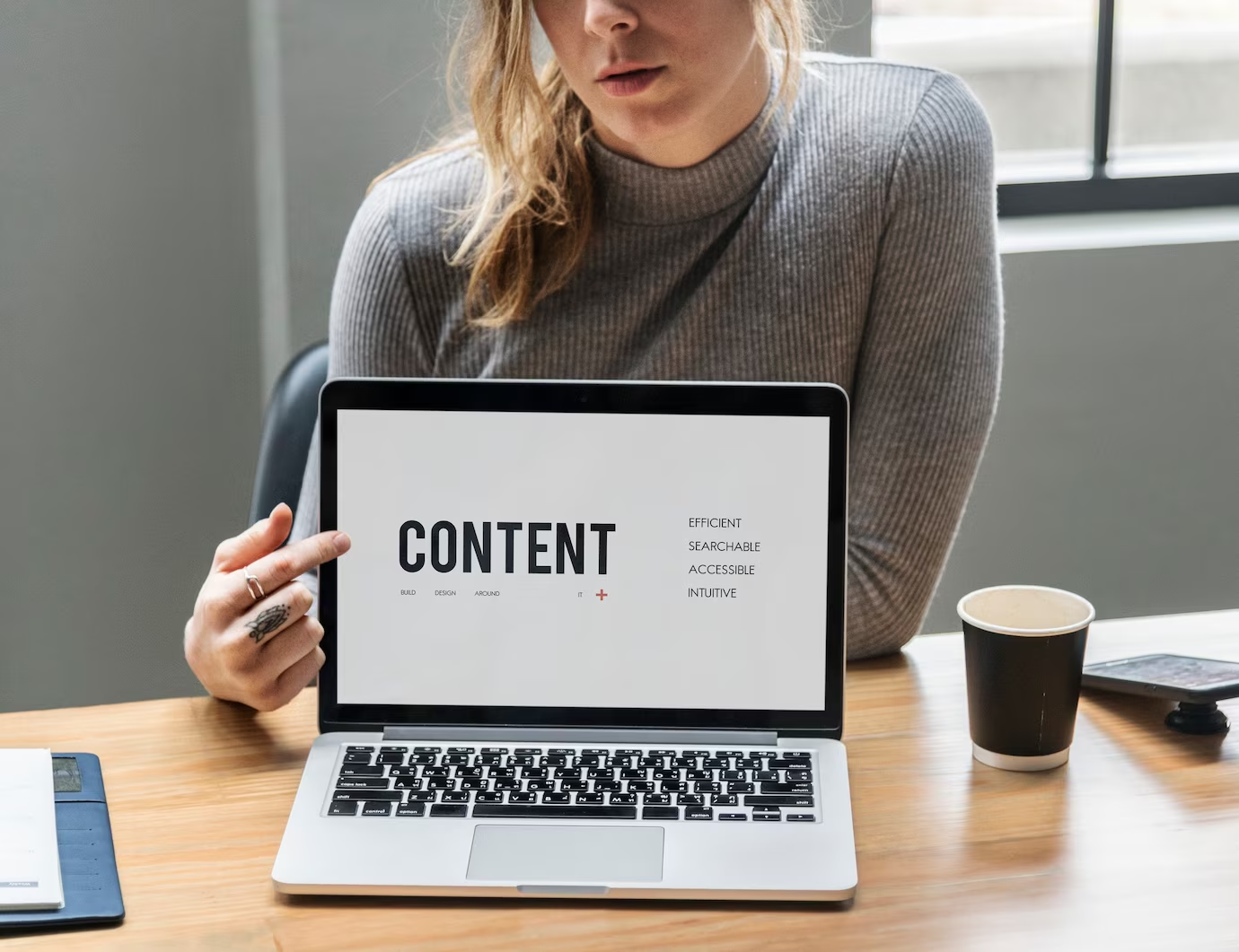 A girl pointing towards content on her laptop.