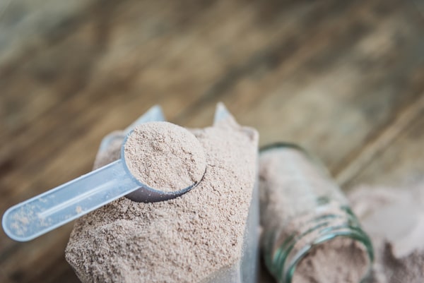 Protein powder with a teaspoon placed on top