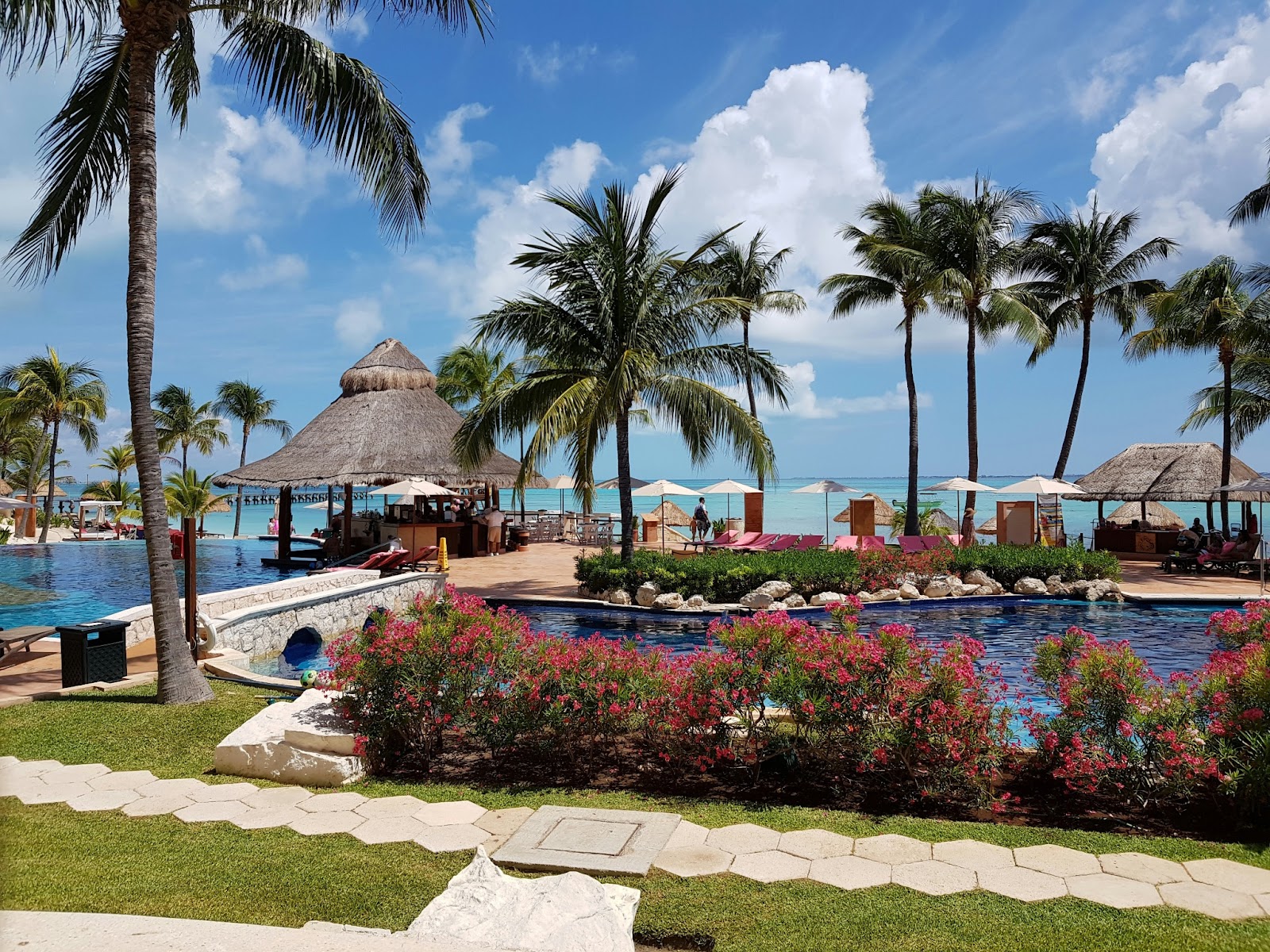 A lavish resort pool with a stunning ocean view, perfect for a romantic getaway in Mexico.