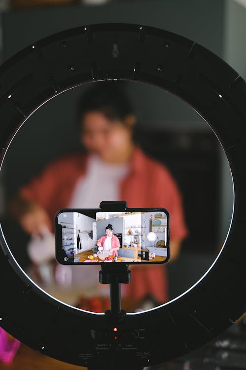 Free Phone on a Tripod Recording a Woman Cooking  Stock Photo