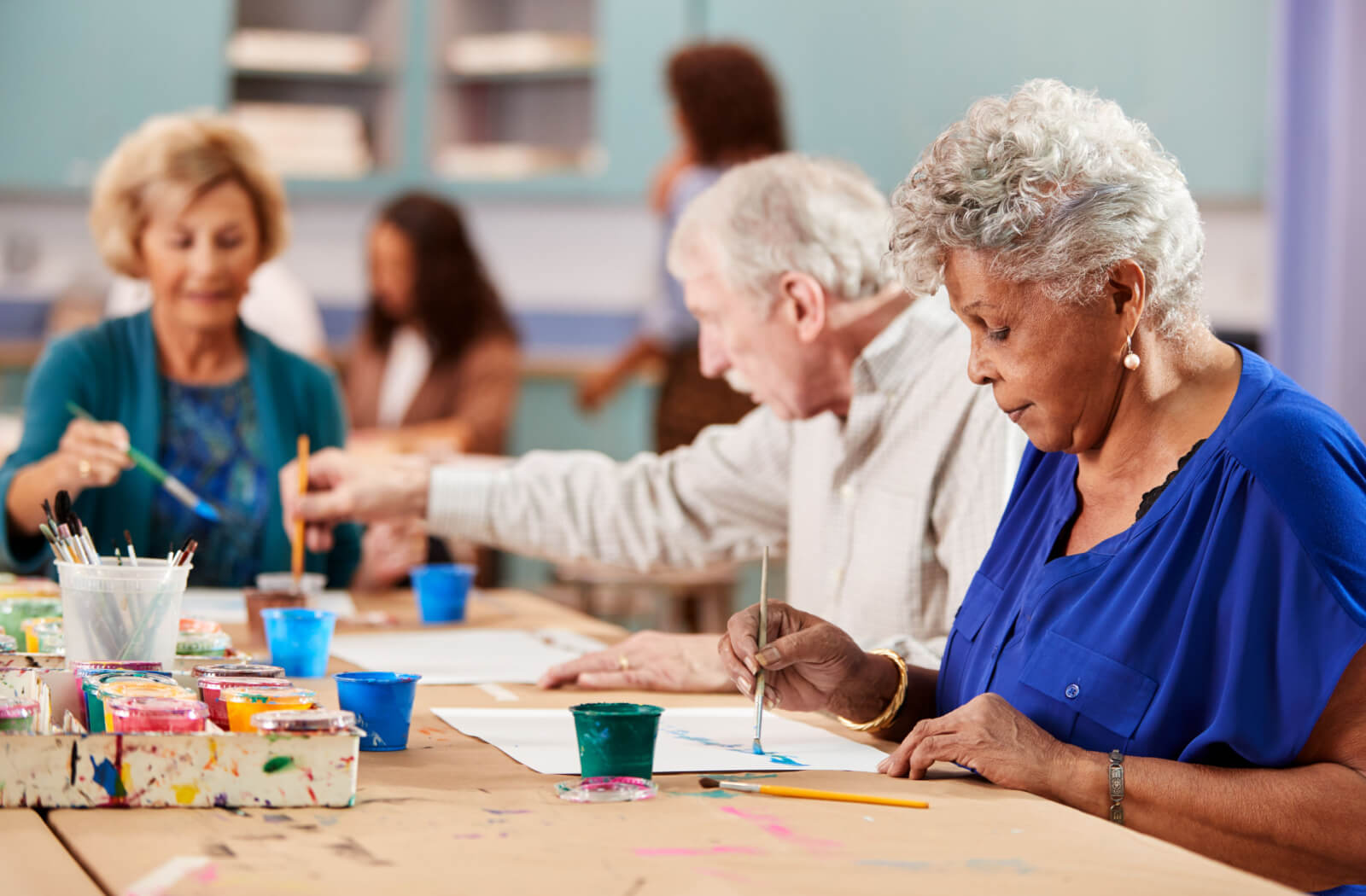 A group of seniors in an art class learning how to paint.