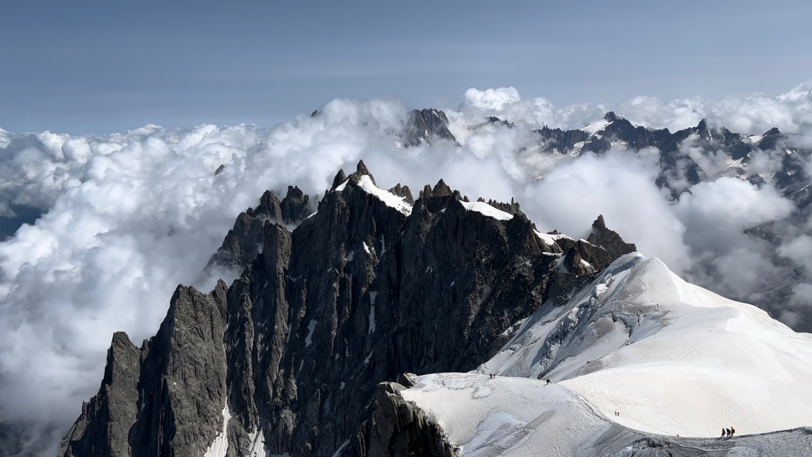 En bas à droite, des alpinistes sur le point de descendre le Mont Blanc