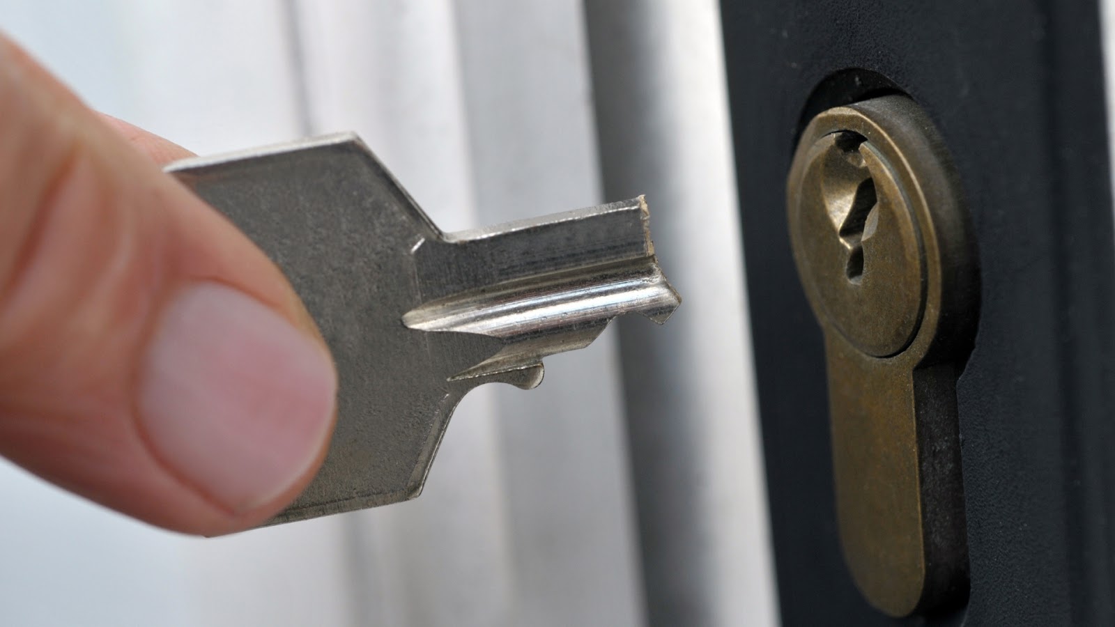 A user pulling a broken key off a lock