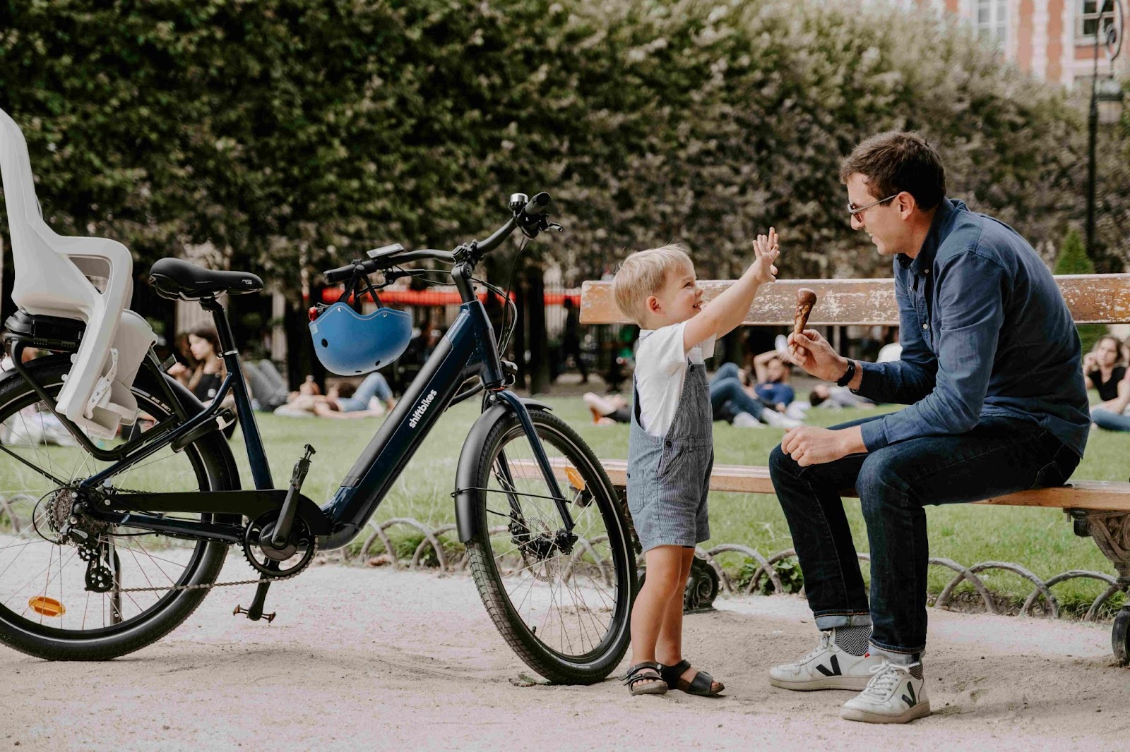 Un père et son enfant qui ont louer un vélo électrique dans un parc