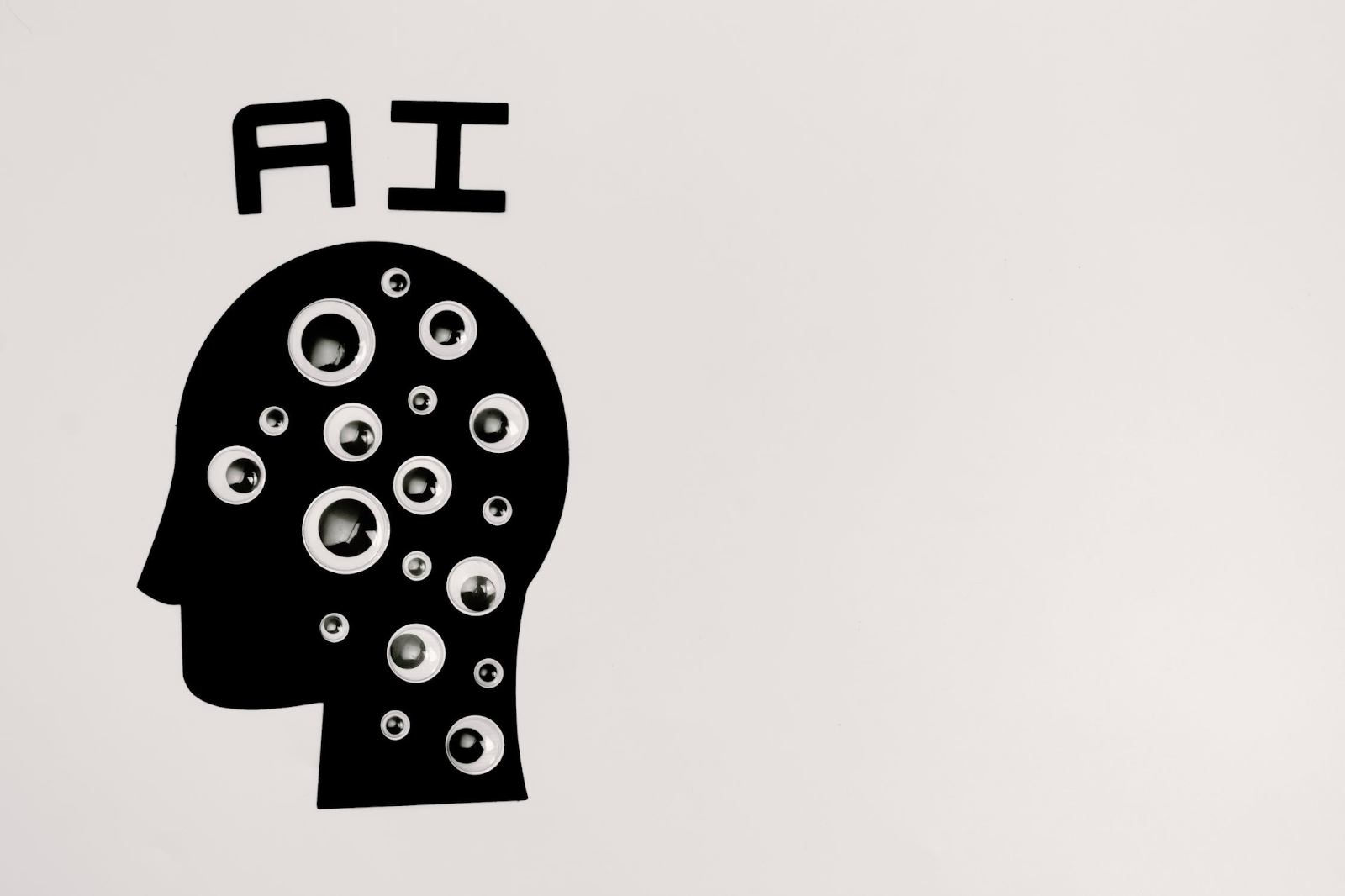 An illustration of a head with lots of googly eyes inside it and the letters AI on top