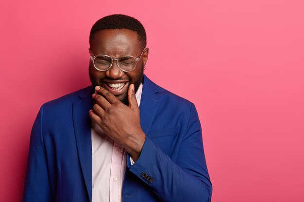 A man in glasses laughing his heart out.