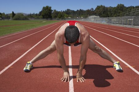 Runner Stretching to Start Running on Track.