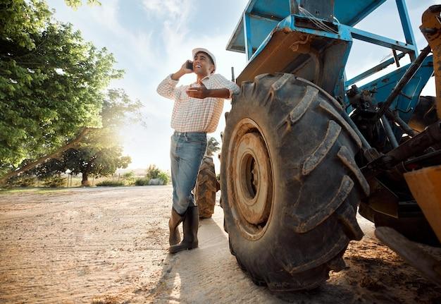 Photo ill be able to sell these and many more shot of a young man talking on a cellphone while working on a farm