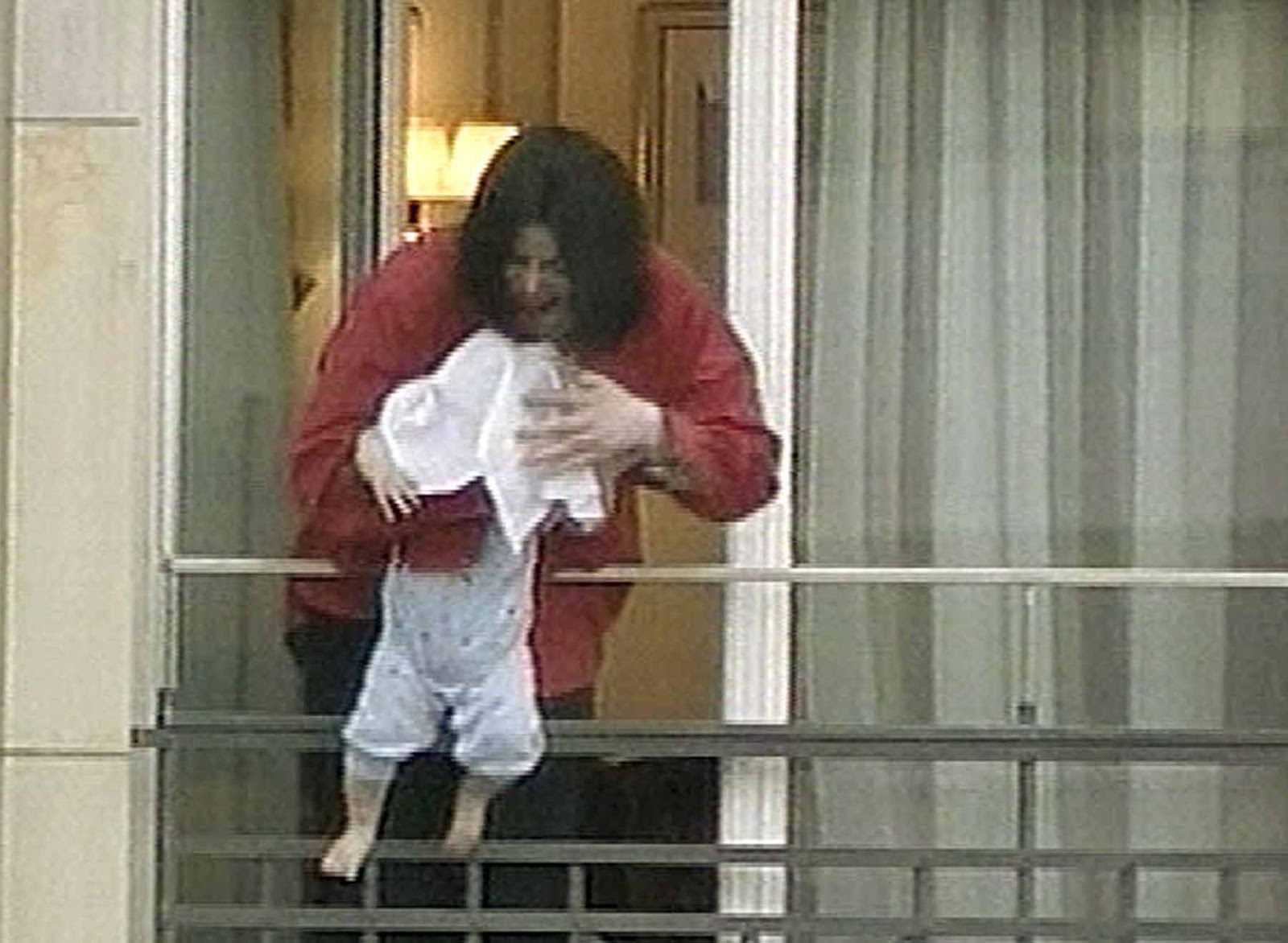 Michael Jackson håller sin bebis utanför en hotellbalkong i Tyskland 2002. Foto: AP/TT