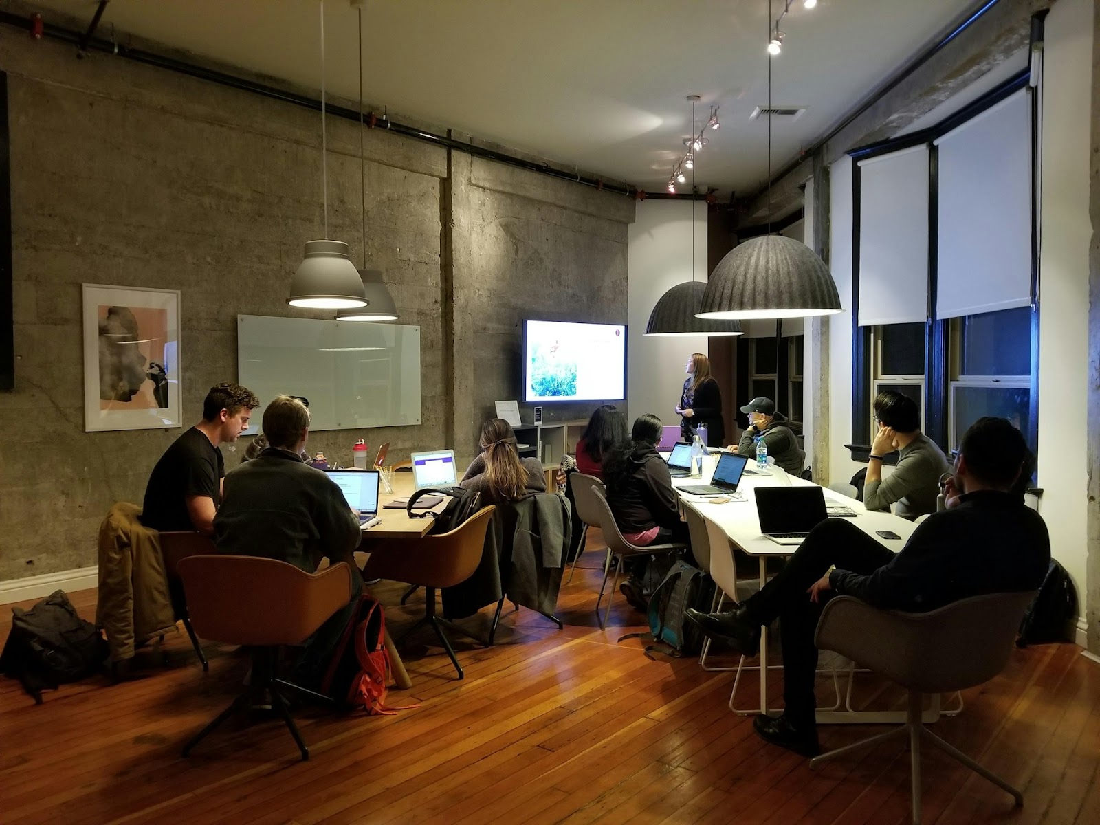 A team of colleagues working together in an office, sitting at tables and engaged in their tasks.