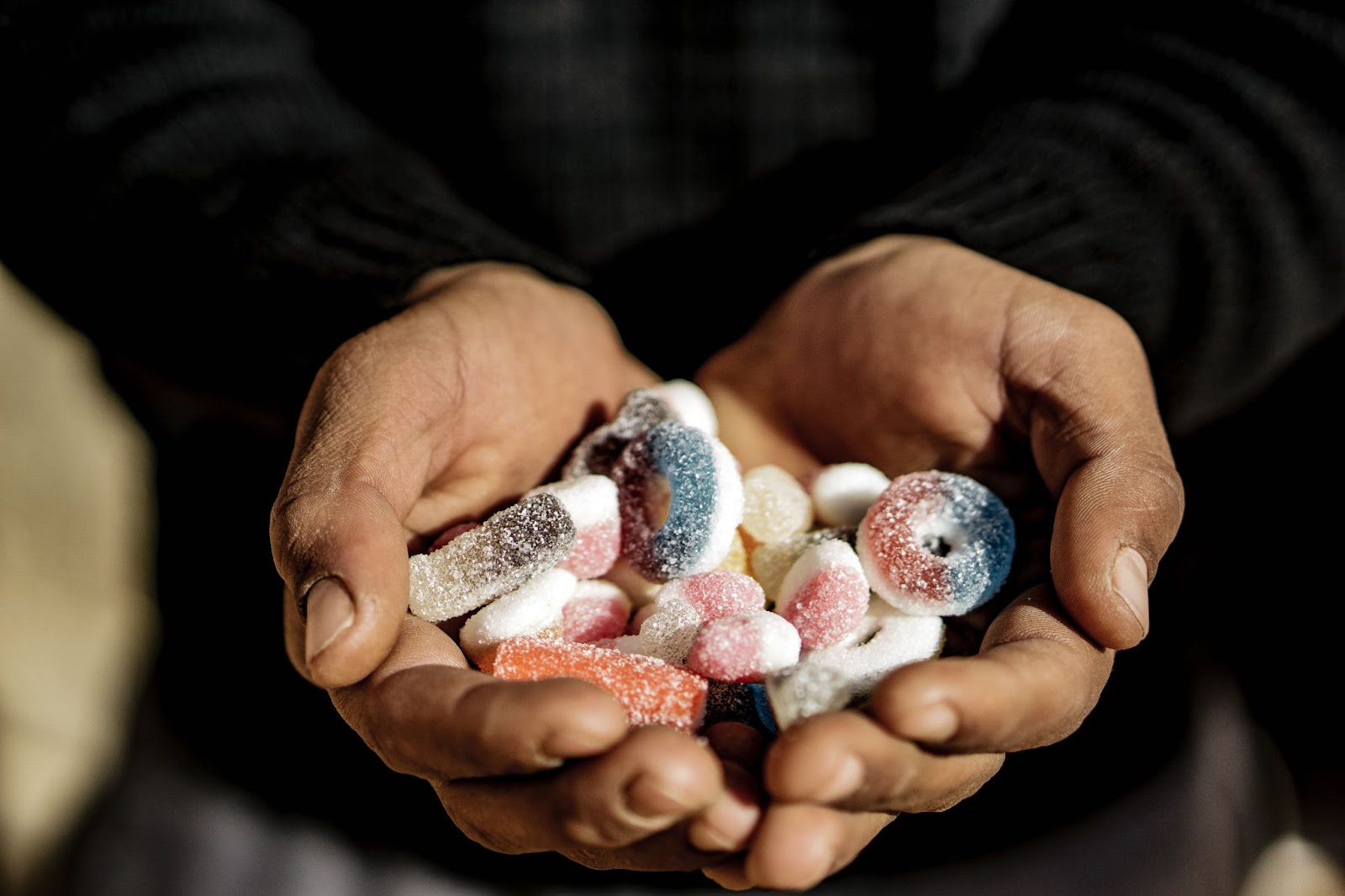 Person holding sour candy in their hands.