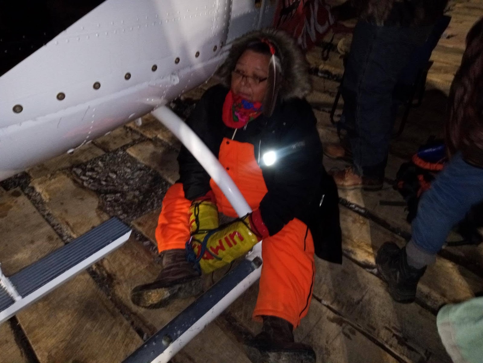 An indigenous female activist sits handcuffed to the base of a helicopter