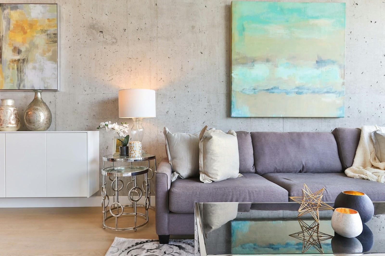 a living room with a gray sofa and a watercolor painting