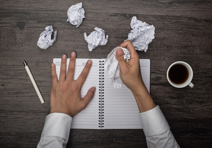 Frustrated person tearing papers, illustrating the challenges of dysgraphia.