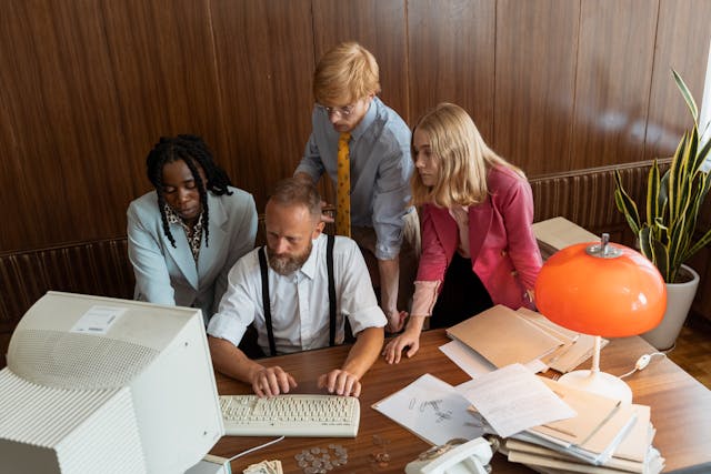 A group of people in the office looking at the computer