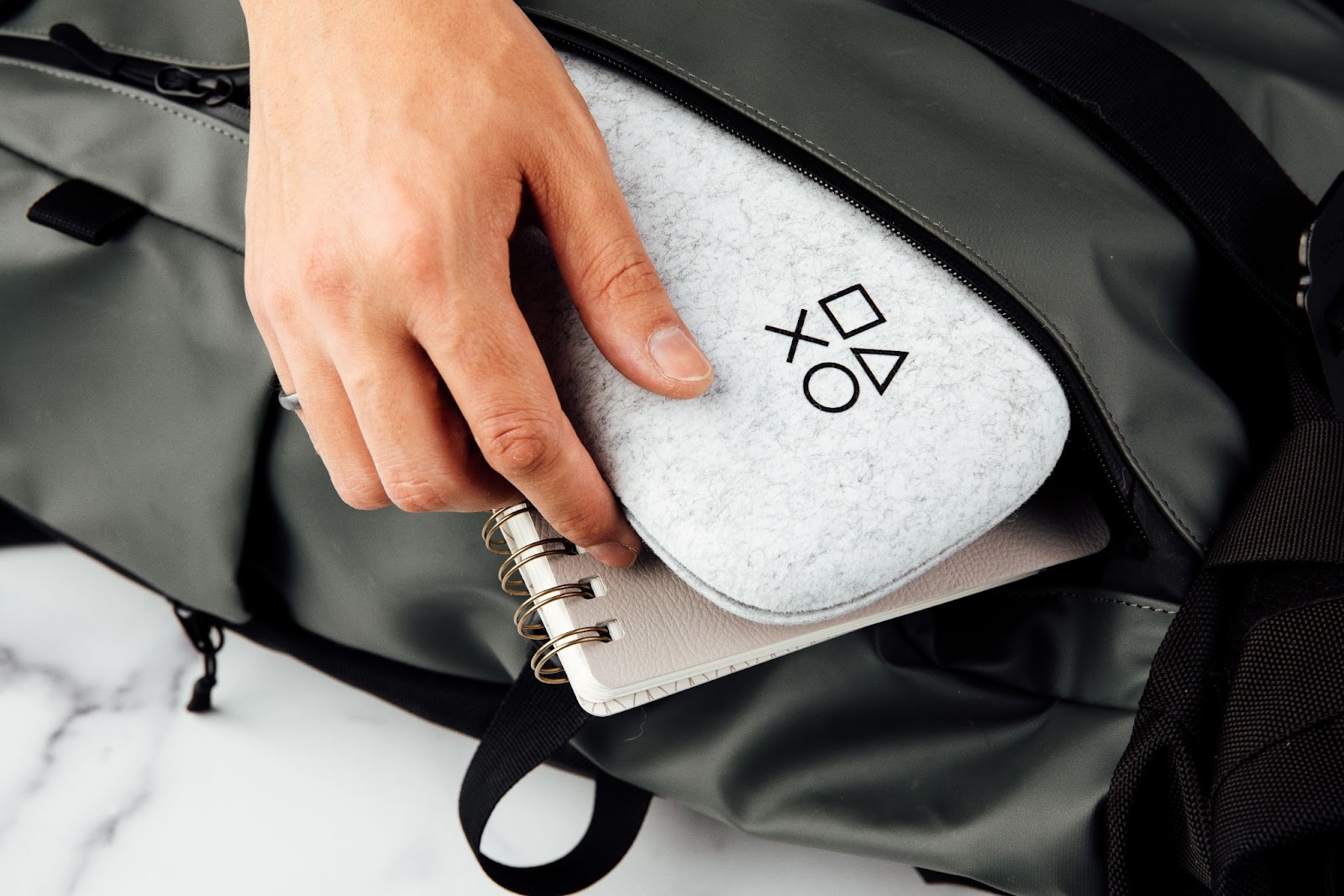 White PlayStation® Edition Backbone One Carrying Case being packed into a bag.