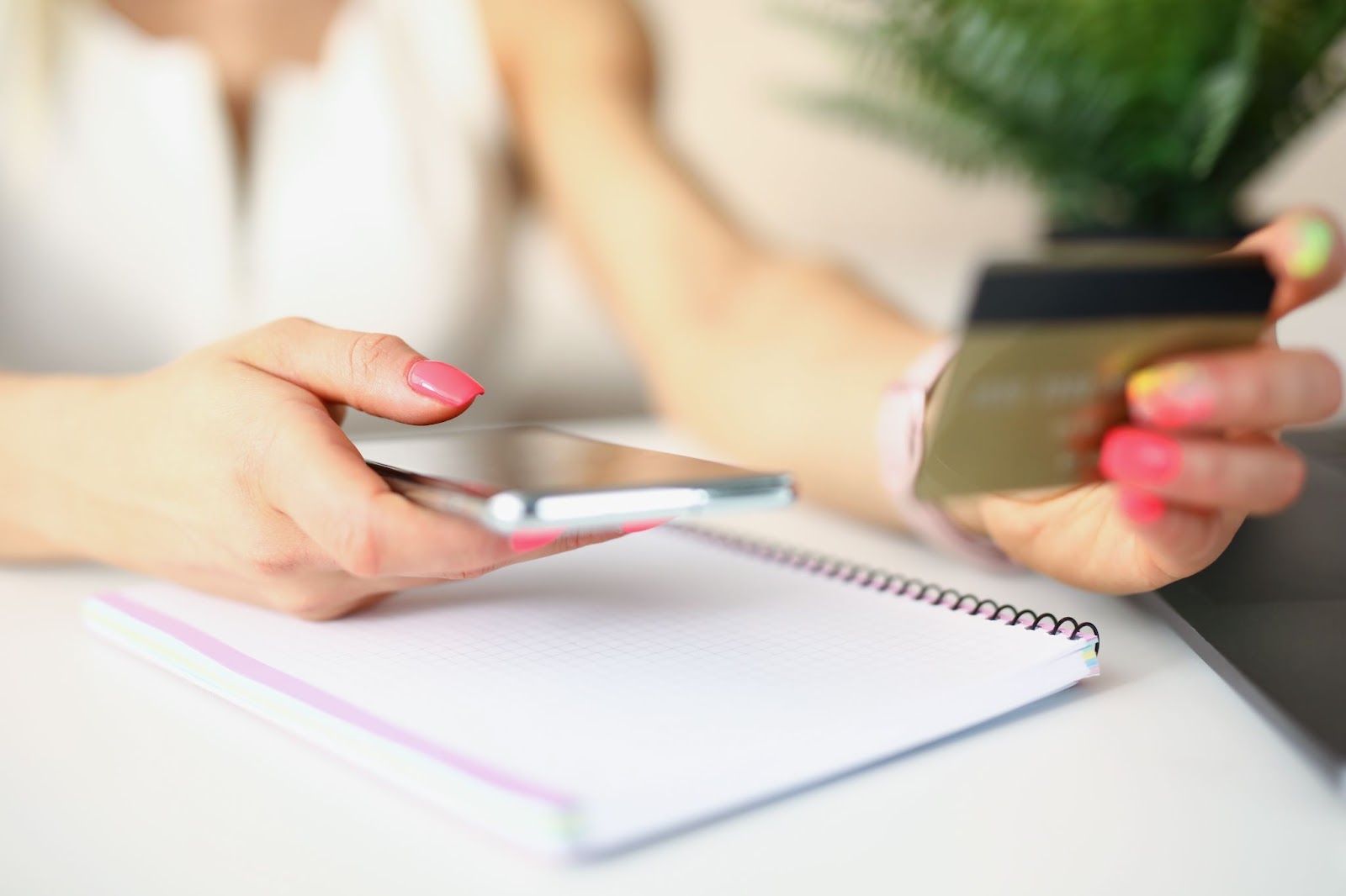 woman holding a credit card and a phone