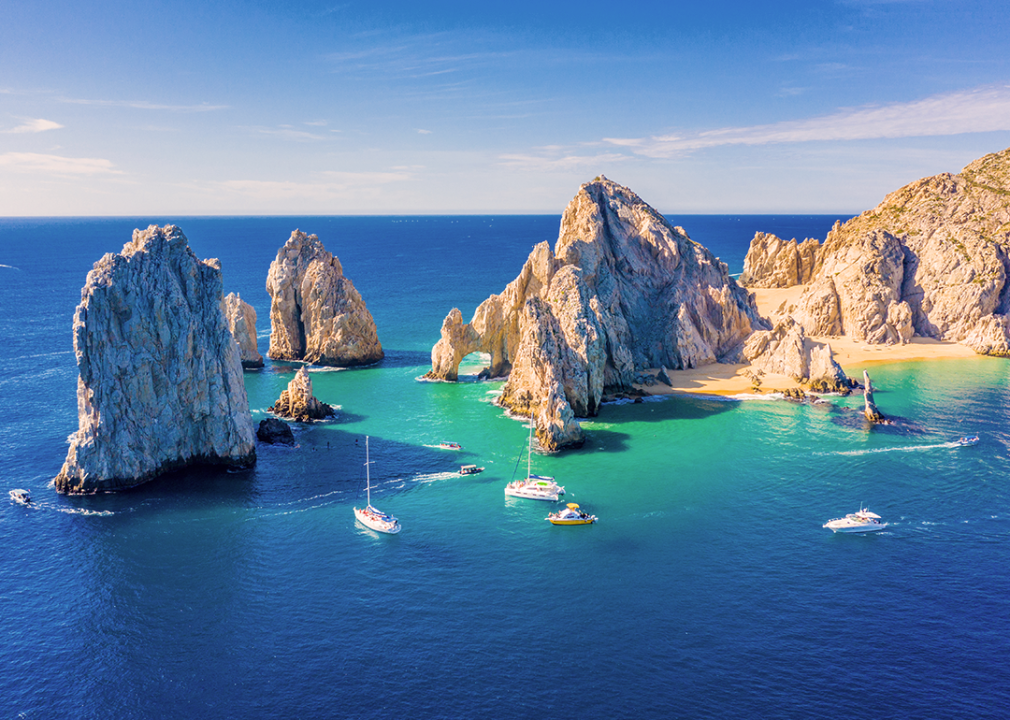 An aerial view of El Arco with a few boats sitting in the bay. 