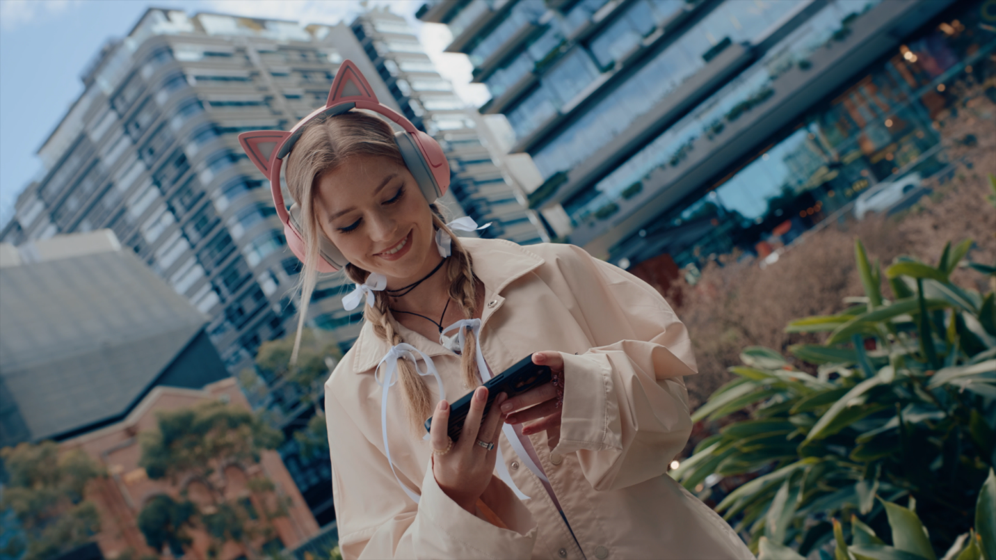 A person wearing headphones and holding a phone

Description automatically generated