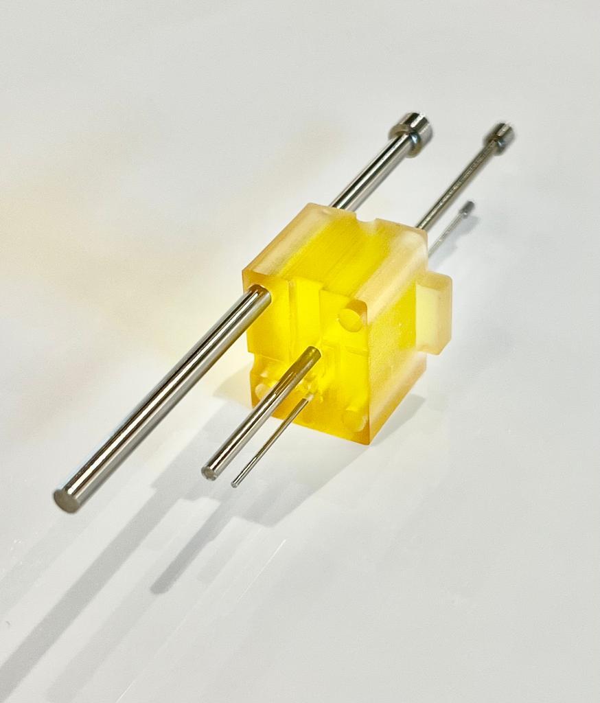 A yellow plastic object with metal rods

Description automatically generated