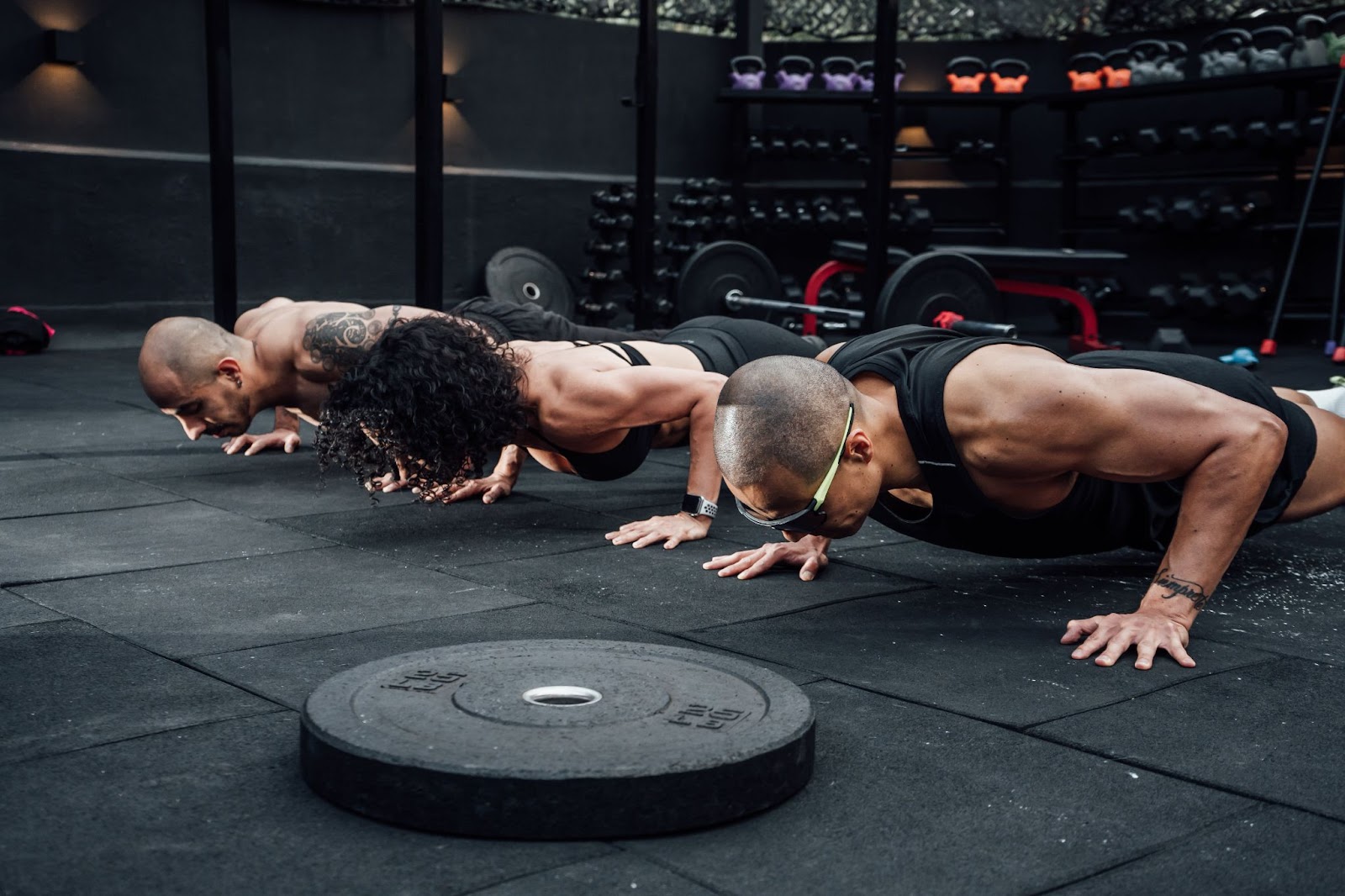 Three men doing push-ups in a gym