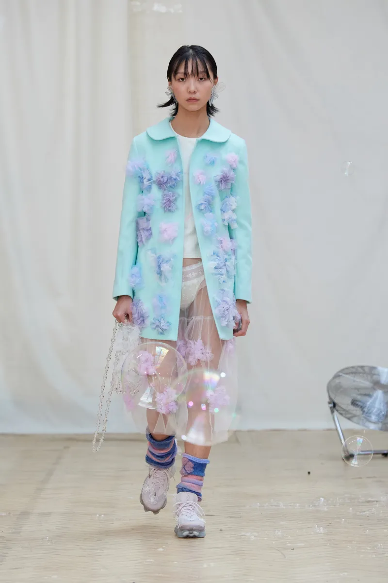 Picture showing a model in blue flowery coat for Susan fang