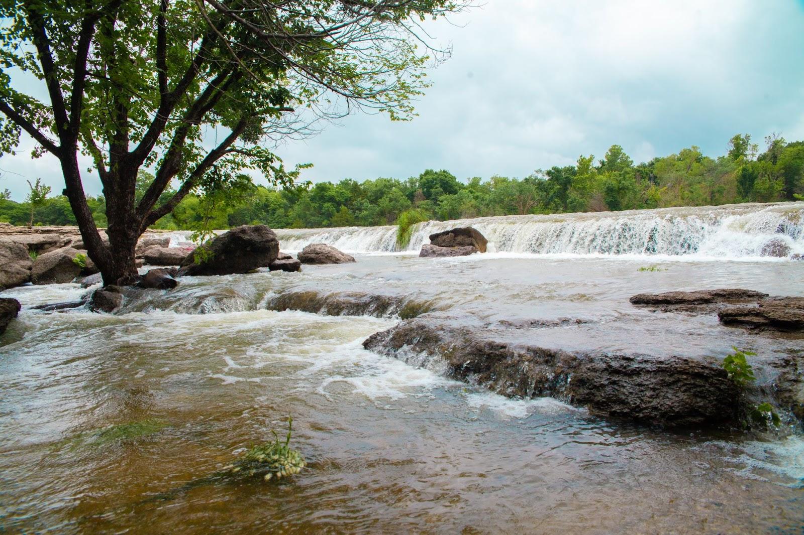 a waterfall with rocks and trees