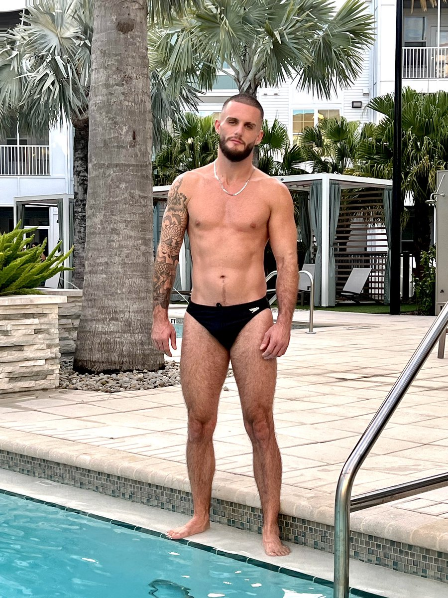Tony Salas standing in a black speedo near the pool outside