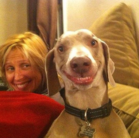 a woman and a dog with both having their teeth out