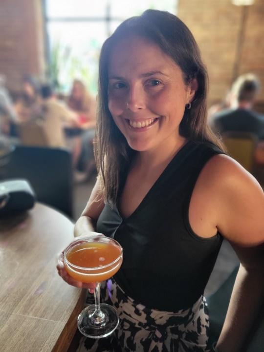 A person smiling and holding a glass of beer

Description automatically generated with medium confidence
