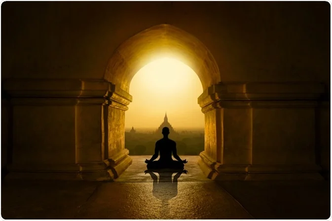 A person is seen taking part in meditation as the sun shines in the sky.
