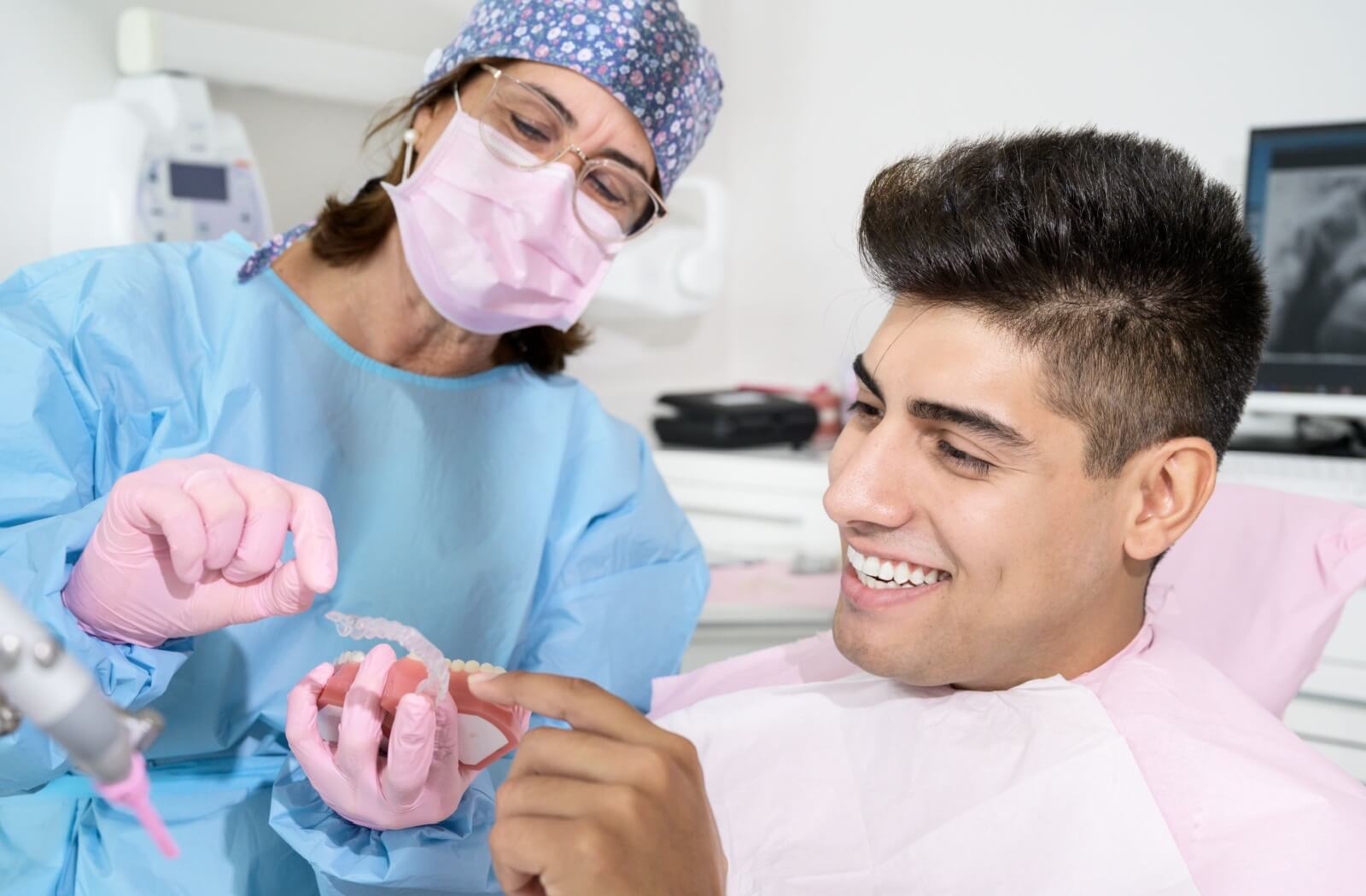 A dentist showing her patient an Invisalign brace.
