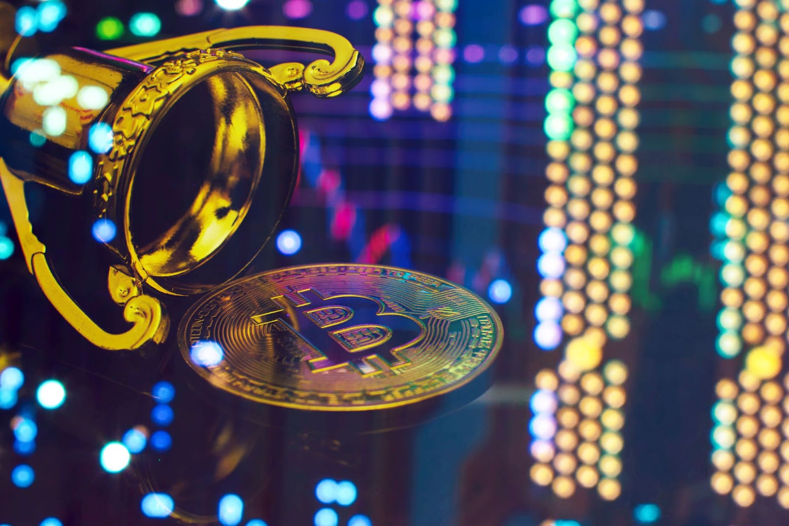 A golden trophy cup tipped over with a Bitcoin coin spilling out, set against a backdrop of vibrant, colorful bokeh lights.