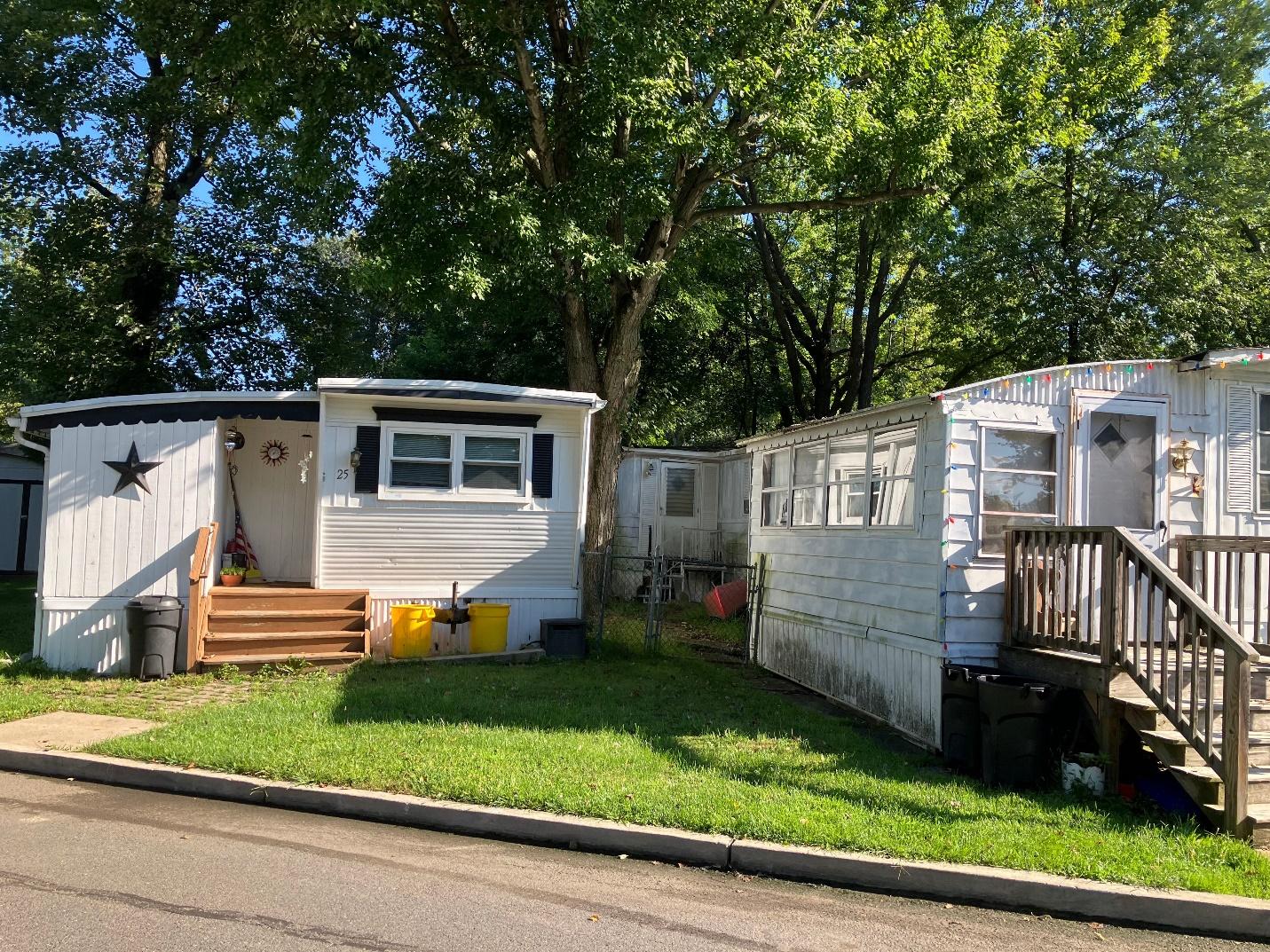 A trailer park with trees and a sidewalk

Description automatically generated with medium confidence