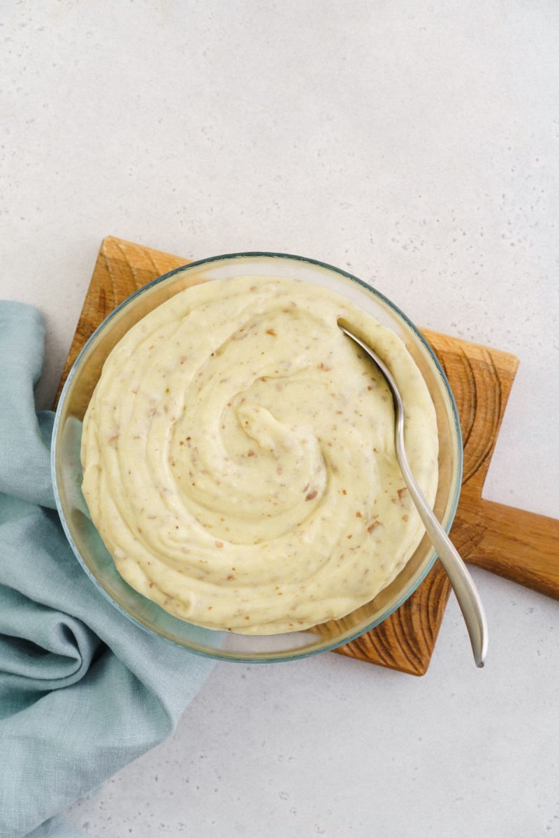 Red skin mashed potatoes in a bowl on a cutting board.