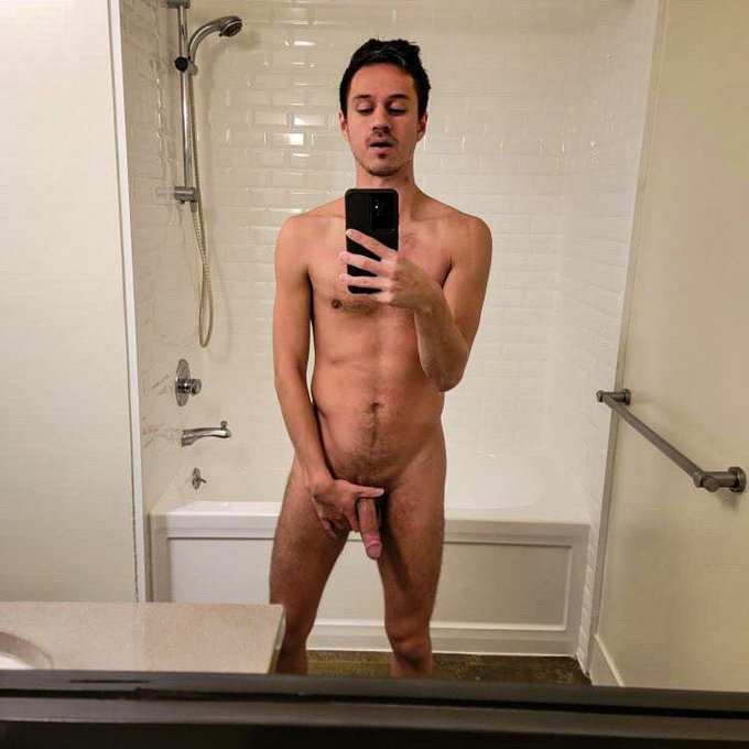 Dakota Wonders taking a selfie in the bathroom naked tugging at his half erect penis