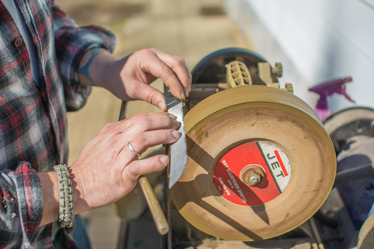 An image of a knife being sharpened by a grinding wheel. This image is meant to accompany the concept of sharpening the saw.