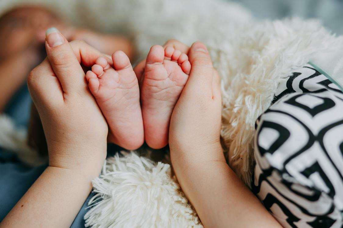 赤ちゃんの足を保持している人関連の無料ストックフォト