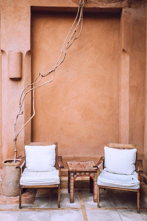 Free Aged armchairs near small table in patio Stock Photo