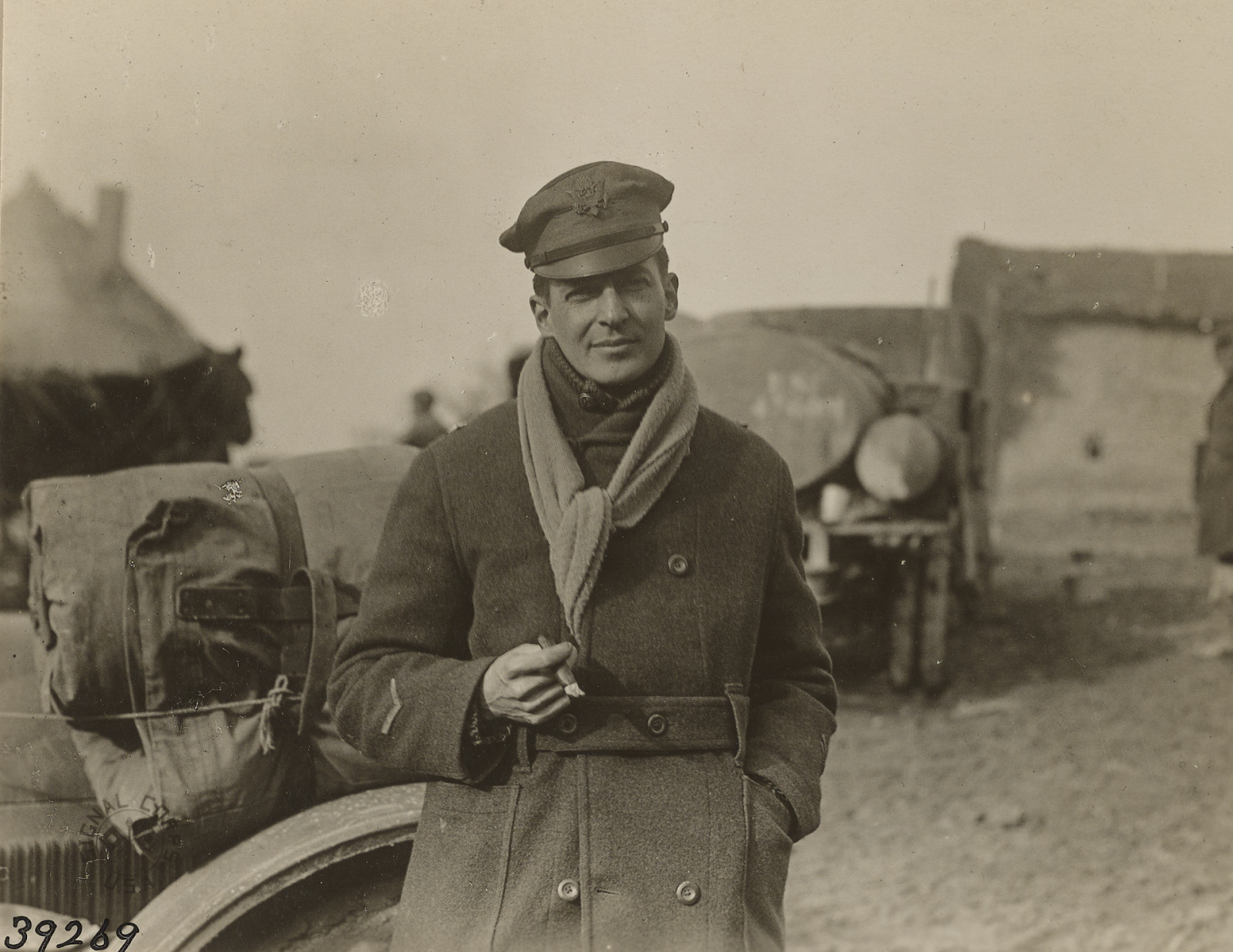 Brig. Gen. Douglas McArthur smoking a cigar and standing in front of his car.