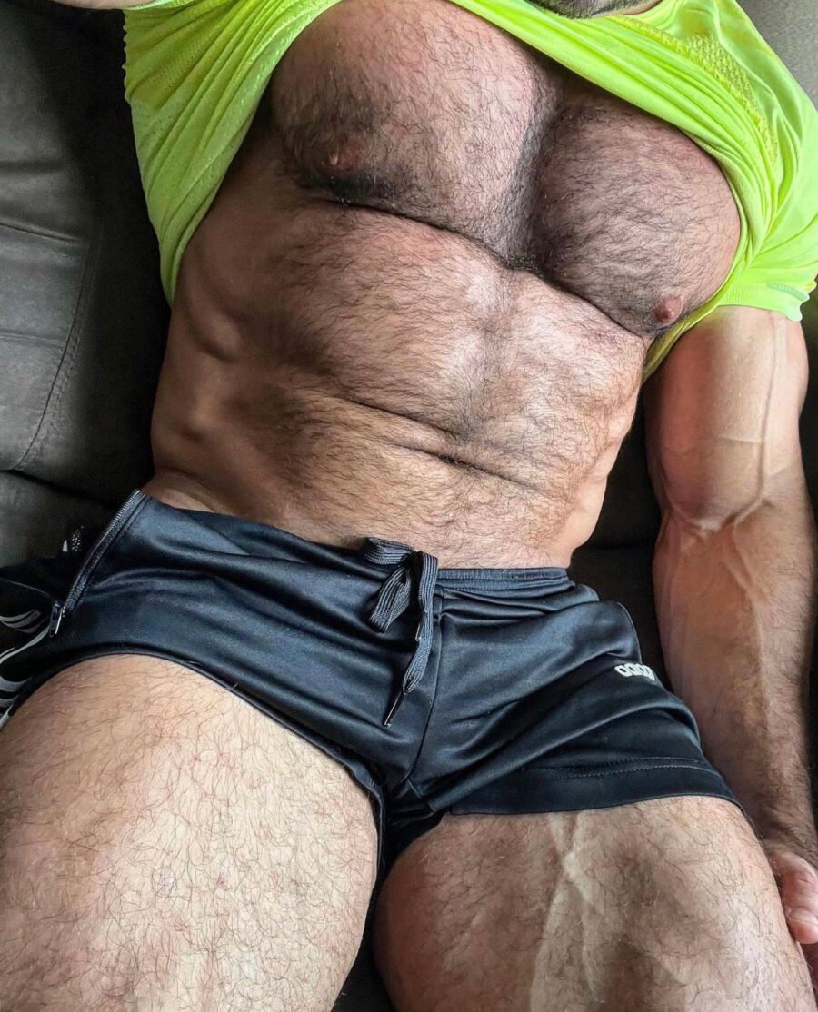 gay hairy muscle male busts out of his florescent athletic shirt and gym shorts to reveal his hairy muscle chest